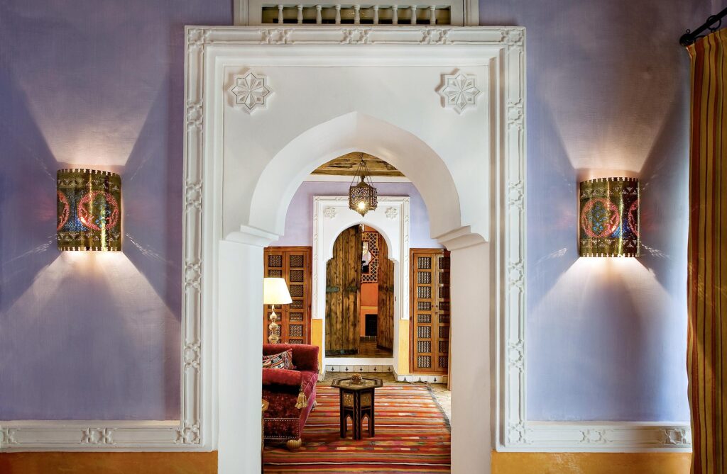 Entrée voûtée d'un riad avec appliques murales artisanales menant à un salon traditionnel, Dar El Hadir à Tozeur